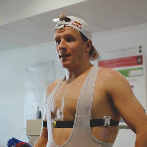 Kristian Blummenfelt shirtless, wearing a sensor and doing athletic training
