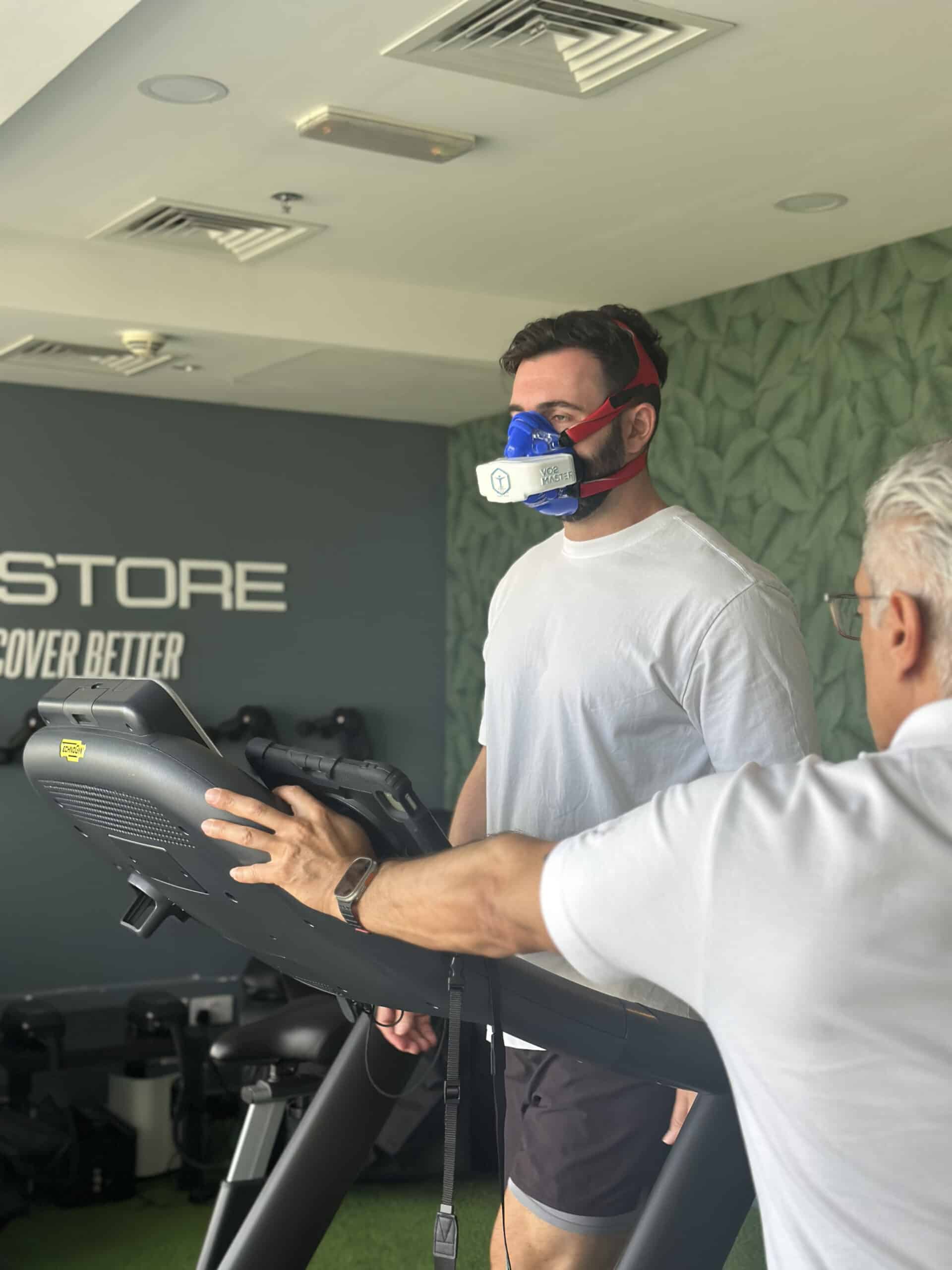 Athlete performing VO2 max test using VO2 Master Analyzer at Restore Fitness Dubai, guided by coach during metabolic performance assessment.